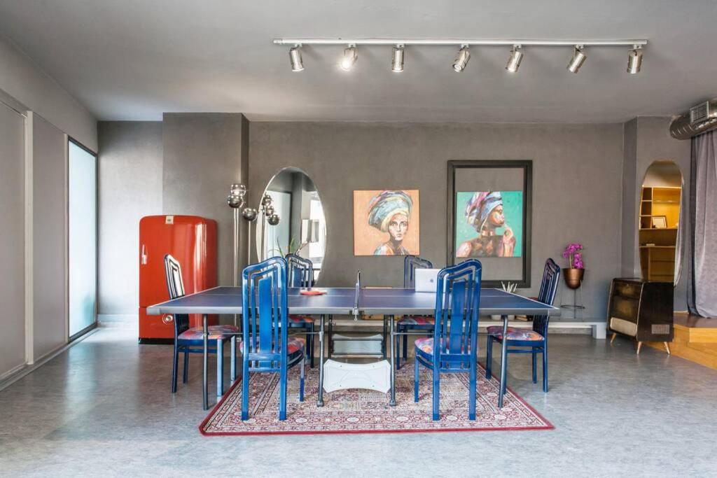 jadalnia ze stołem i niebieskimi krzesłami w obiekcie Artists’ favorite Spacious Loft near Acropolis!! w Atenach