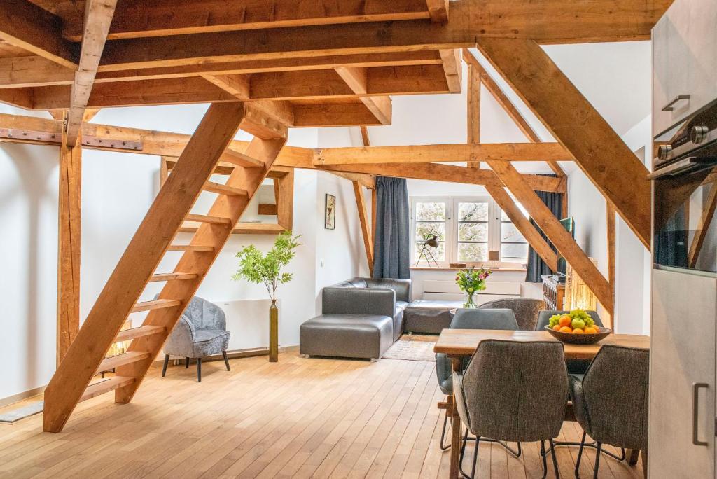 Zimmer mit Holzbalken und einem Wohnzimmer in der Unterkunft Spoorzicht Long Stay Apartments in Loppersum