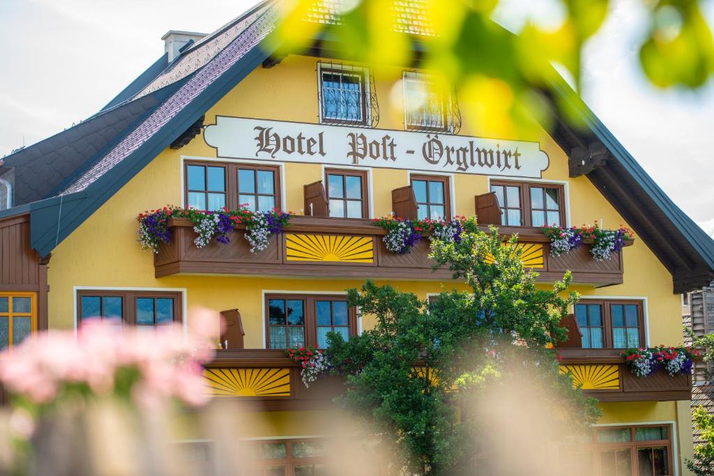 un bâtiment jaune avec un panneau indiquant l'appartement d'hôtel dans l'établissement Örglwirt Ferienwelt - Hotel Post Örglwirt, à Mariapfarr