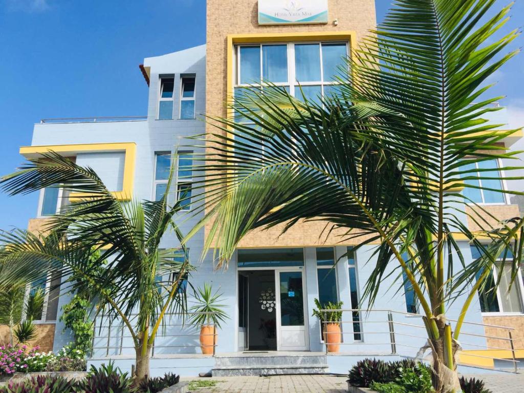 un bâtiment avec des palmiers en face de celui-ci dans l'établissement Vista Mar, à Tarrafal