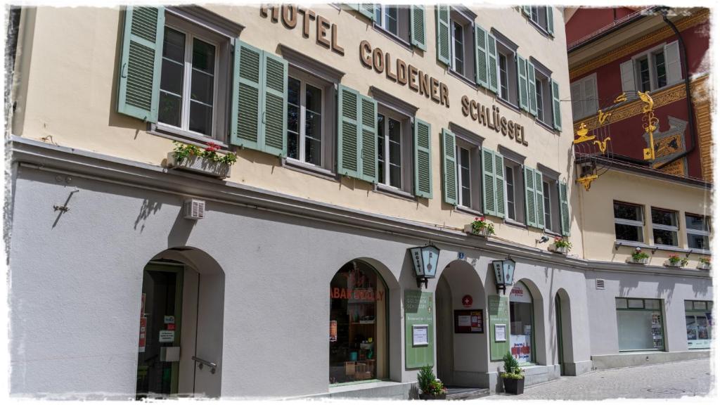 um edifício com persianas verdes numa rua em Hotel Restaurant Goldener Schlüssel em Altdorf