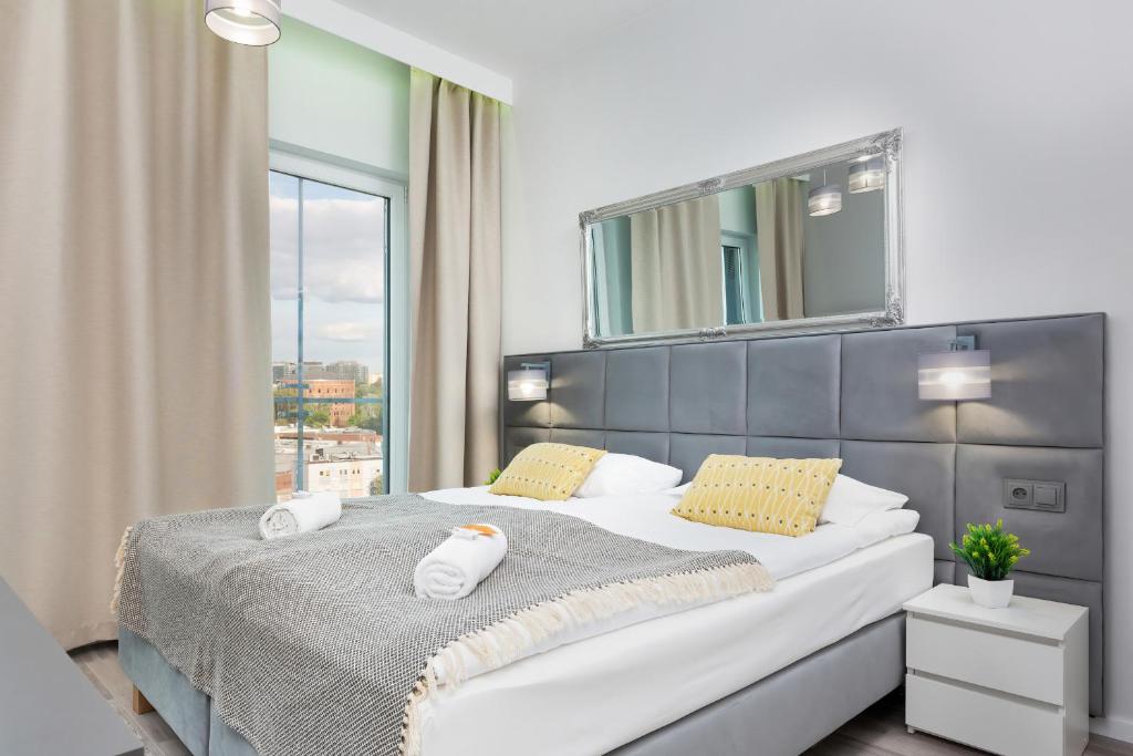a bedroom with a large bed with a mirror at Apartments with parking Warsaw Business Center by Renters in Warsaw