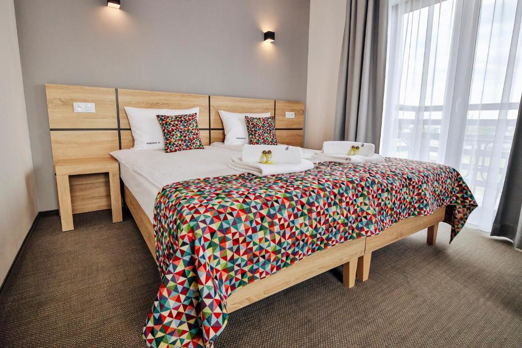 sypialnia z dużym łóżkiem z kolorową narzutą w obiekcie Targowa37 Uniejow w Uniejowie