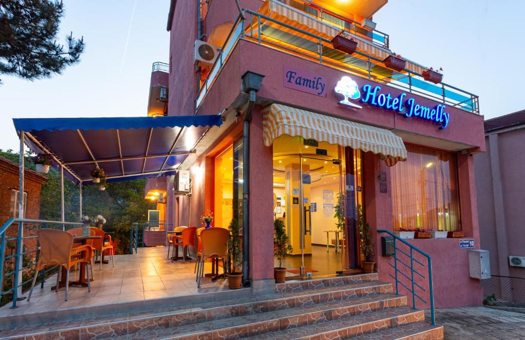 a restaurant with tables and chairs outside of a building at Family Hotel Jemelly in Obzor