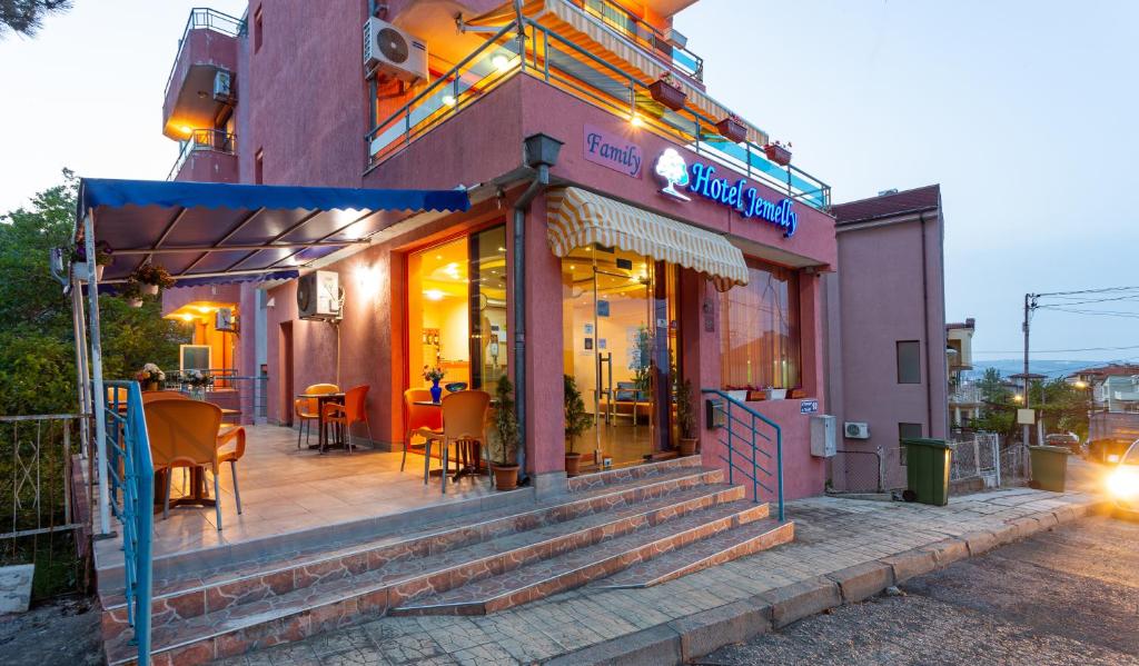 a restaurant with tables and chairs outside of a building at Family Hotel Jemelly in Obzor