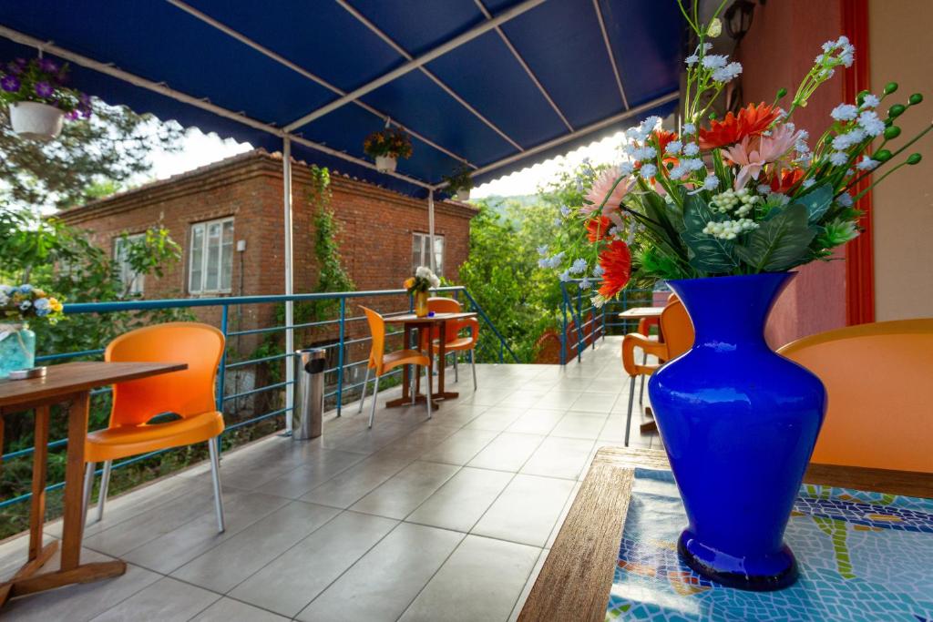 a blue vase filled with flowers sitting on a balcony at Family Hotel Jemelly in Obzor