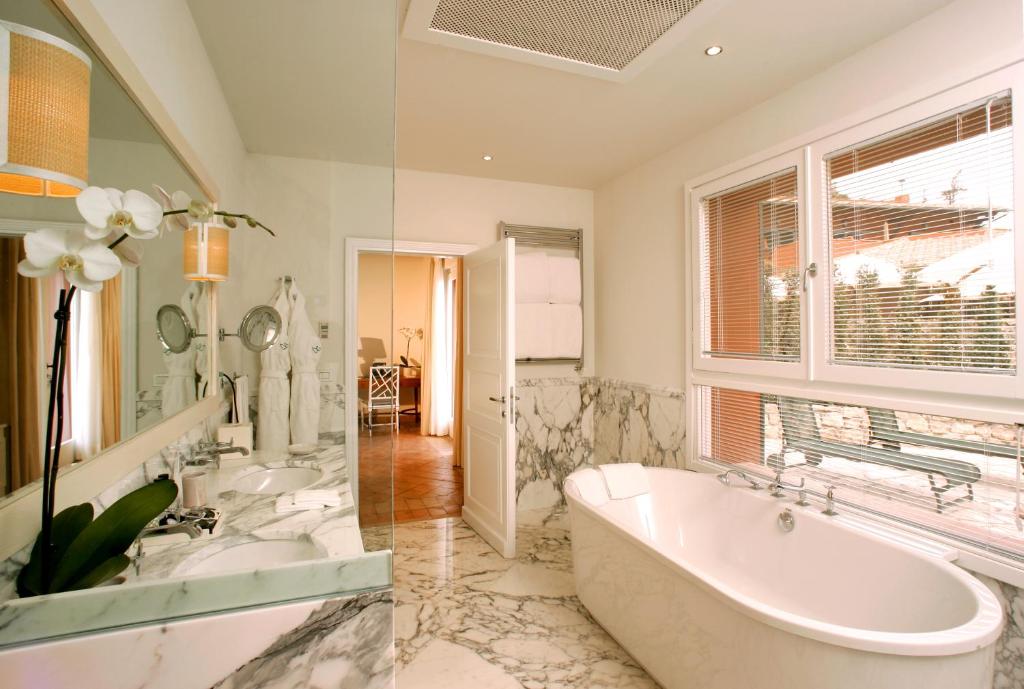 a bathroom with a tub and two sinks and a window at Il Pellicano in Porto Ercole