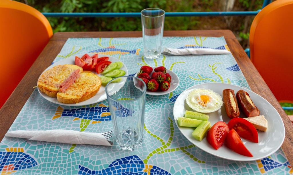 a table with two plates of food and eggs and fruit at Family Hotel Jemelly in Obzor