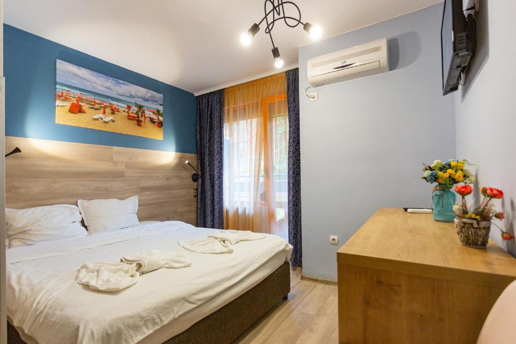 a bedroom with a bed and a desk at Family Hotel Jemelly in Obzor