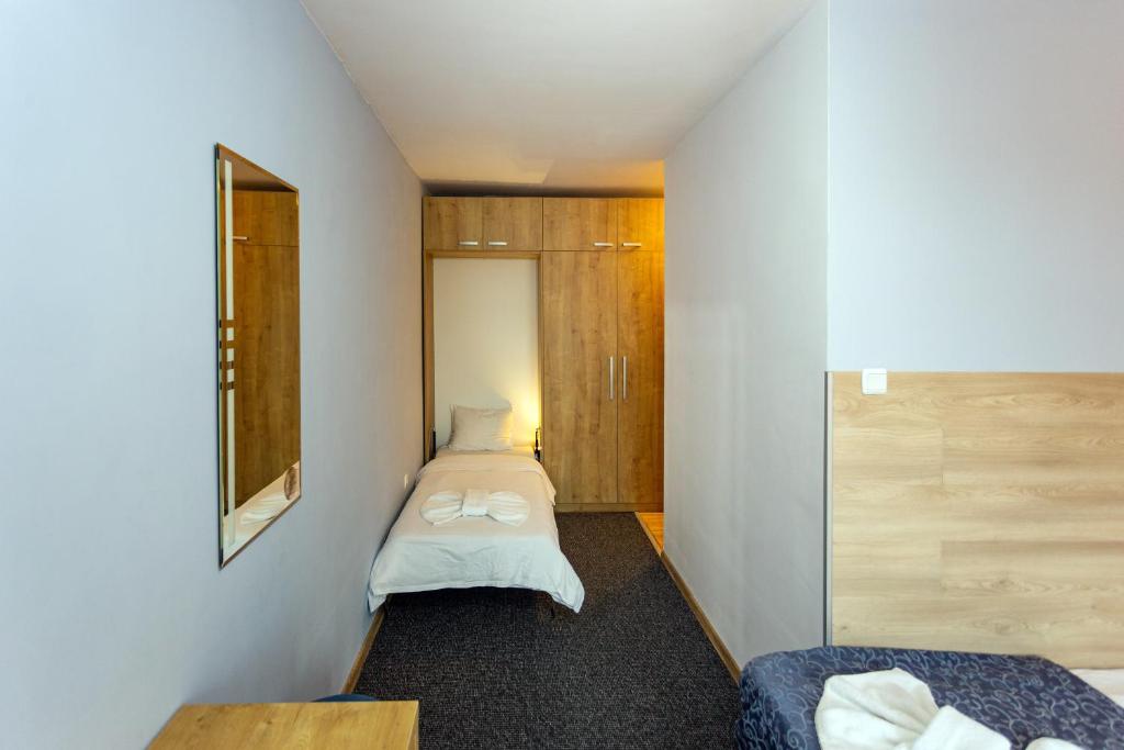 a small room with two beds and a mirror at Family Hotel Jemelly in Obzor