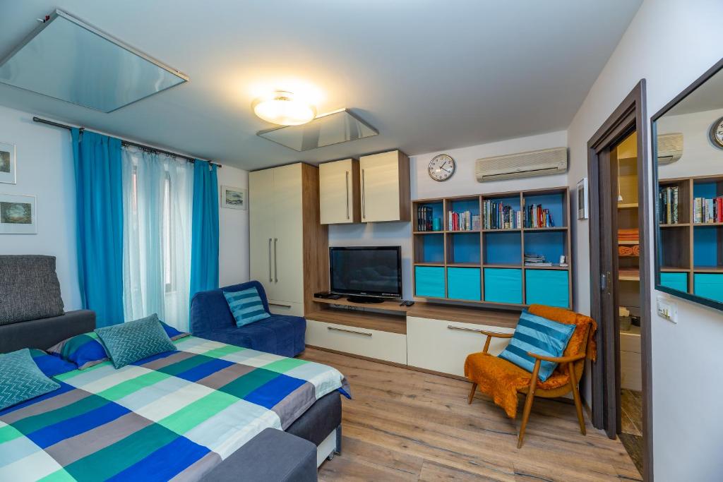 een slaapkamer met een bed, een bank en een tv bij Nono Mario in Piran
