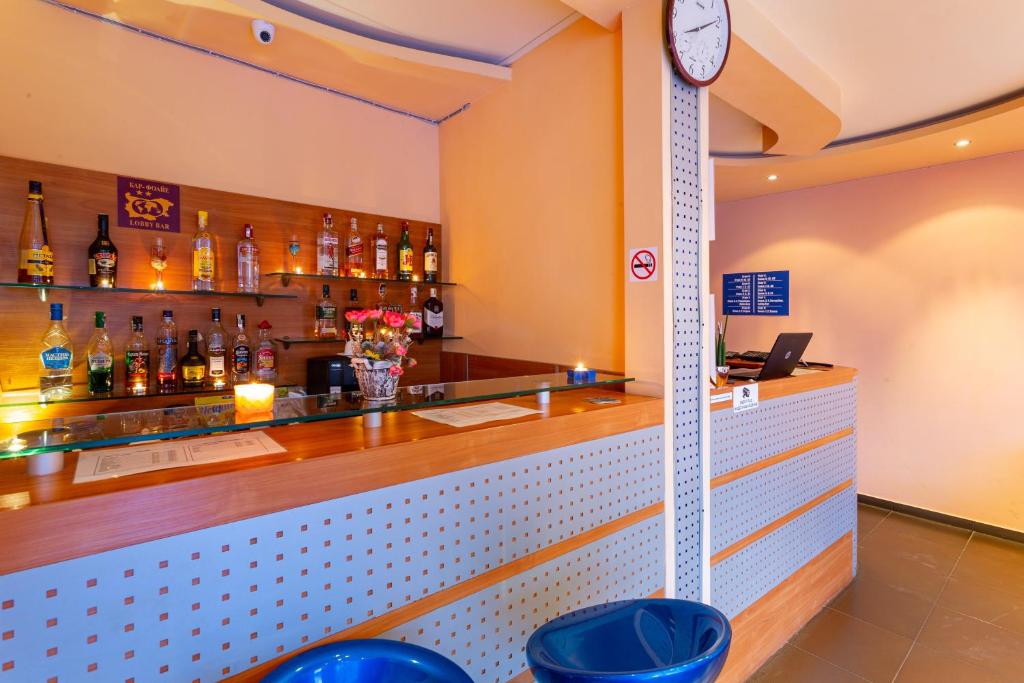 a bar with a clock on the wall at Family Hotel Jemelly in Obzor