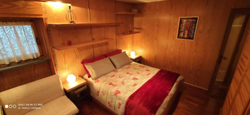 紹澤杜爾克西的住宿－Chalet La Cometa，一间小卧室,配有床和两盏灯