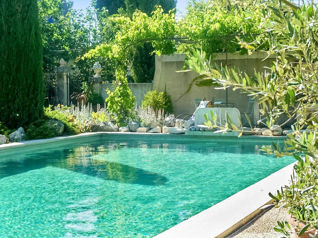 a swimming pool with blue water in a yard at Maison charmante à Oppède avec piscine partagée in Oppède