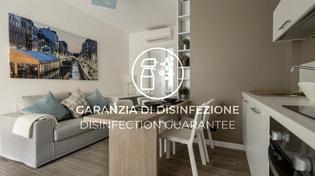 sala de estar con sofá gris y cocina en Italianway - Marcantonio, en Milán