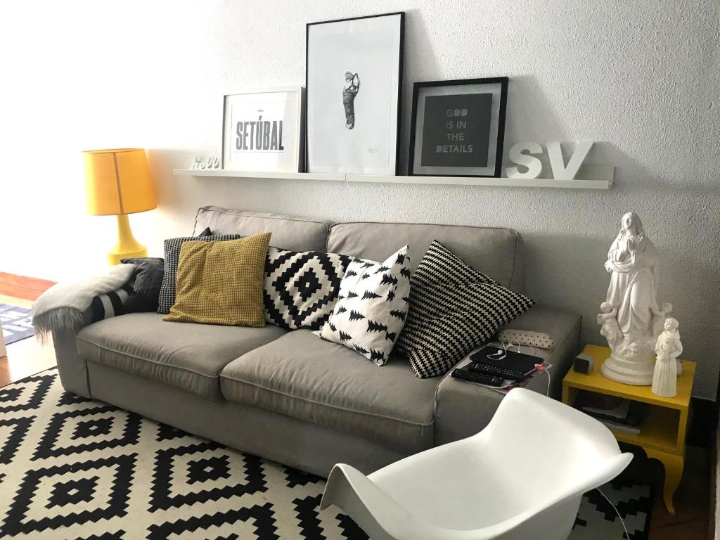 sala de estar con sofá gris con almohadas en casa das conchas, en Tróia