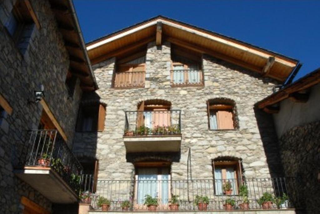 un gran edificio de piedra con ventanas y balcones en Casa Rural Casa Colom, en Espot
