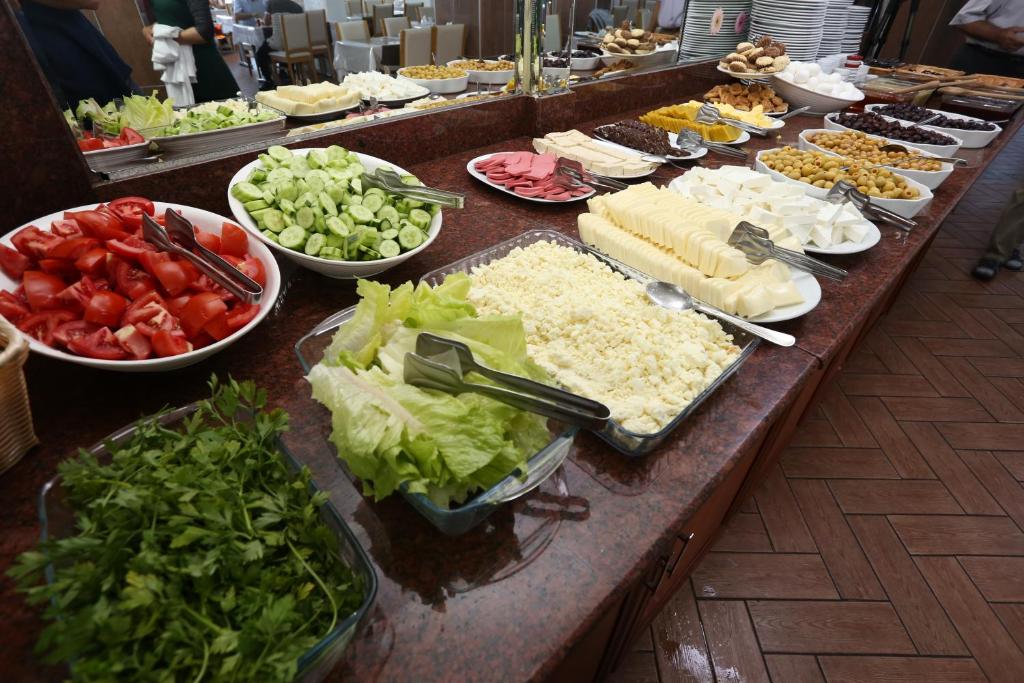 un buffet de plats avec du fromage et des légumes sur une table dans l'établissement Terzioglu Otel, à Hopa