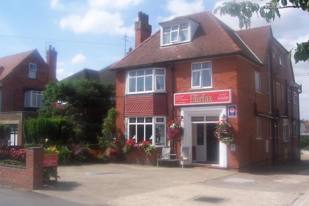 un edificio de ladrillo rojo con una señal roja en él en Fairfax en Skegness