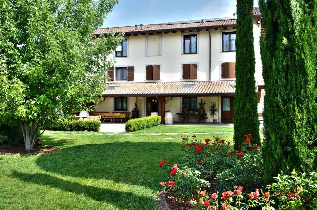 widok na dom z drzewami i kwiatami w obiekcie Agriturismo La Rosta w mieście Cervignano del Friuli