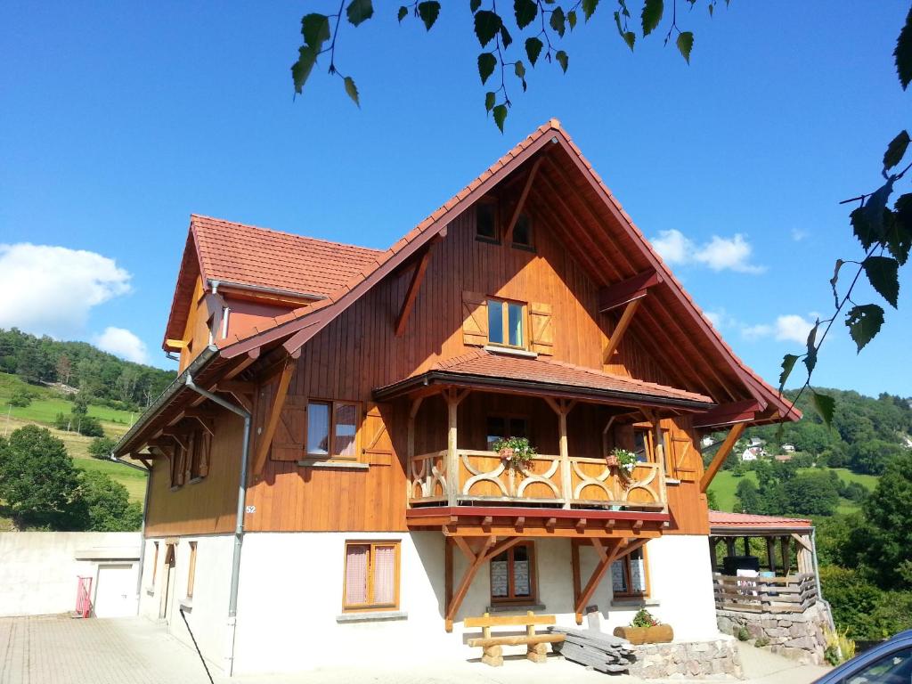 a house with a gambrel roof and a balcony at Appartement chaleureux à Soultzeren avec vue sur montagne in Soultzeren