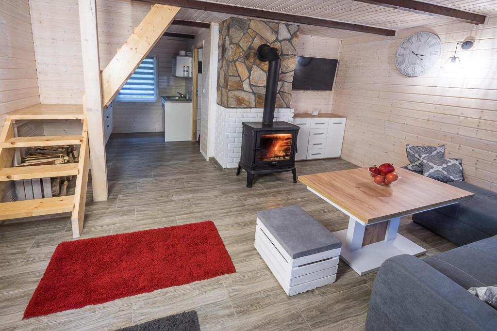 a living room with a fireplace and a stove at DOMKI RODIS in Baligród