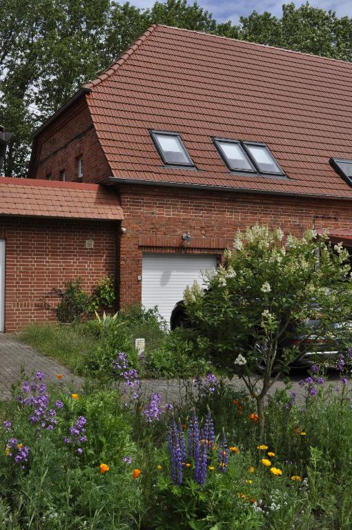 a house with a garage and a garden with flowers at Galerie ebe in Parchim