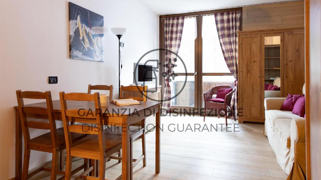 y salón comedor con mesa y sillas. en Italianway - Plagheira 1, en Santa Caterina Valfurva