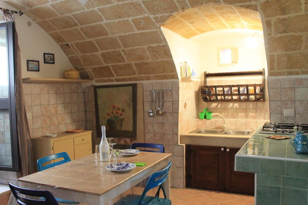 a kitchen with a table with chairs and a sink at Bilocale Dillo alla luna in Gallipoli
