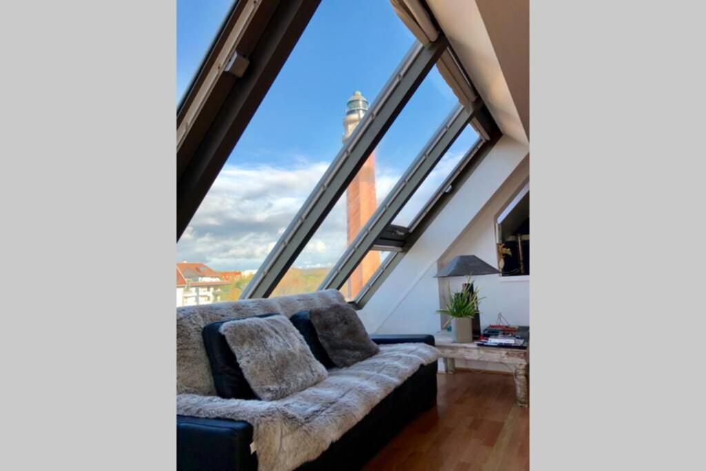 a living room with a couch and large windows at Appartement triangle d'or terrasse garage fermé in Le Touquet-Paris-Plage