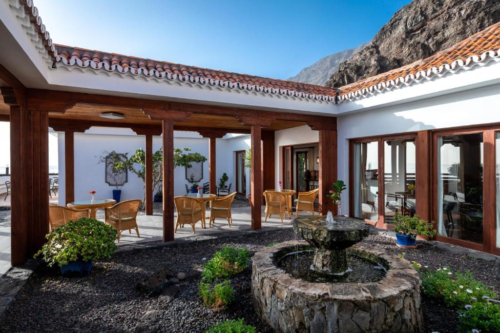 a patio with a fountain and a table and chairs at Parador de El Hierro in Las Casas