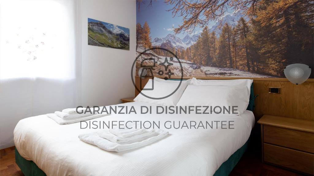 um quarto com uma cama com um quadro na parede em Italianway - San Giovanni 13/A em Bormio