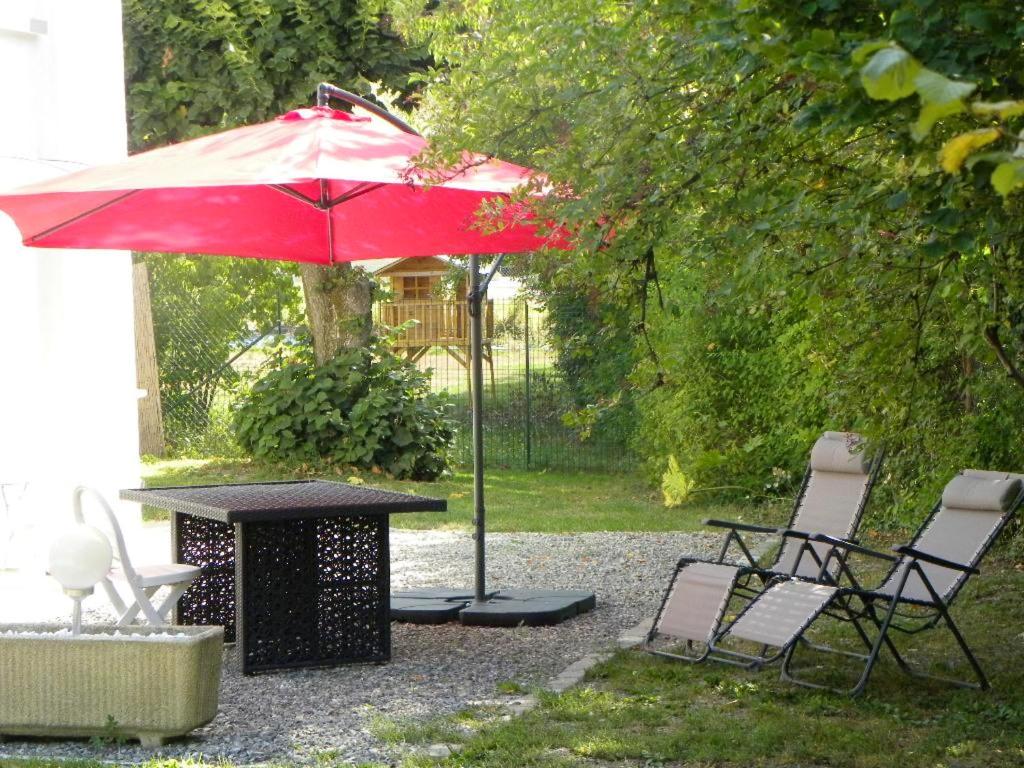 ギャップにあるMaison d'une chambre avec jardin clos et wifi a Gapの赤い傘付きテーブルと椅子
