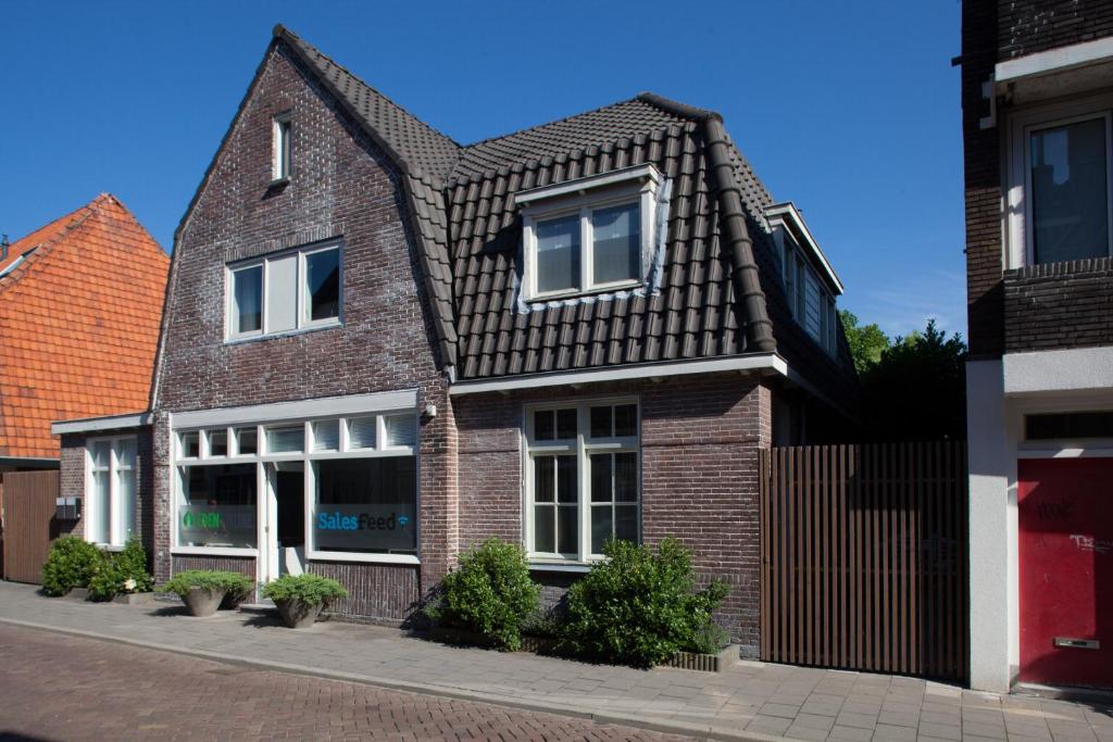 een bruin bakstenen huis met een zwart dak bij Darley's in Hilversum