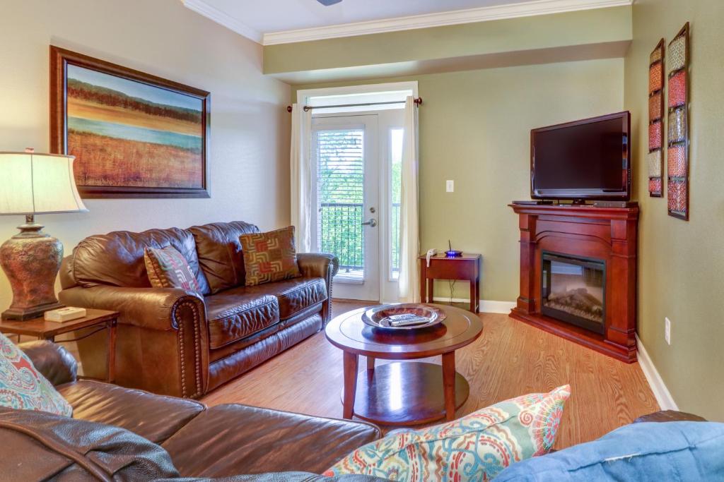 a living room with leather furniture and a fireplace at River Crossing Condominiums - A Beautiful River View in Pigeon Forge