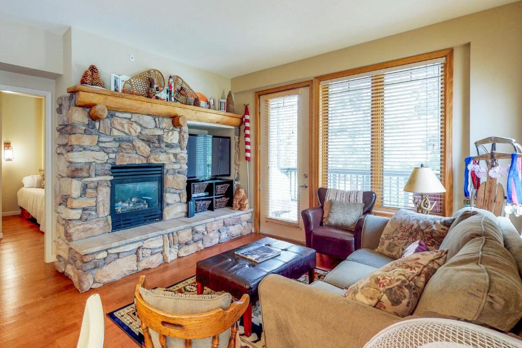 uma sala de estar com uma grande lareira de pedra em Mammoth Green Condos em Mammoth Lakes