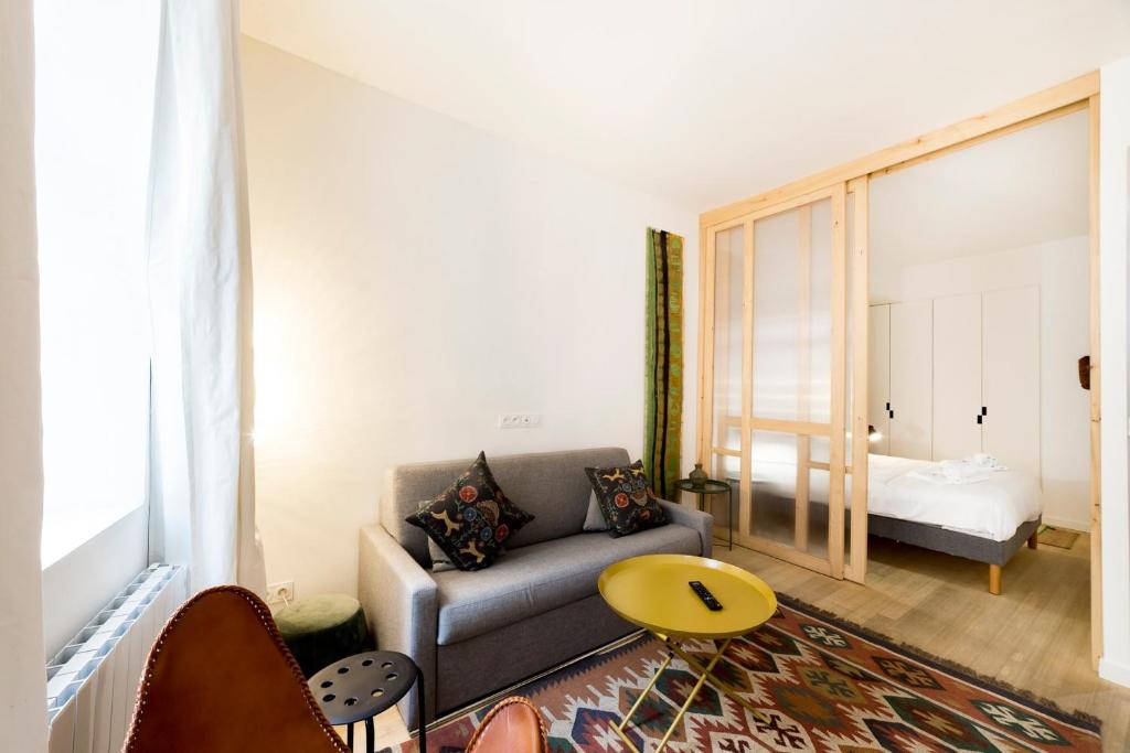 un soggiorno con divano e letto di L'Ethnic Ambience - Superbe appartement tout confort au coeur du Vieux Lyon a Lione