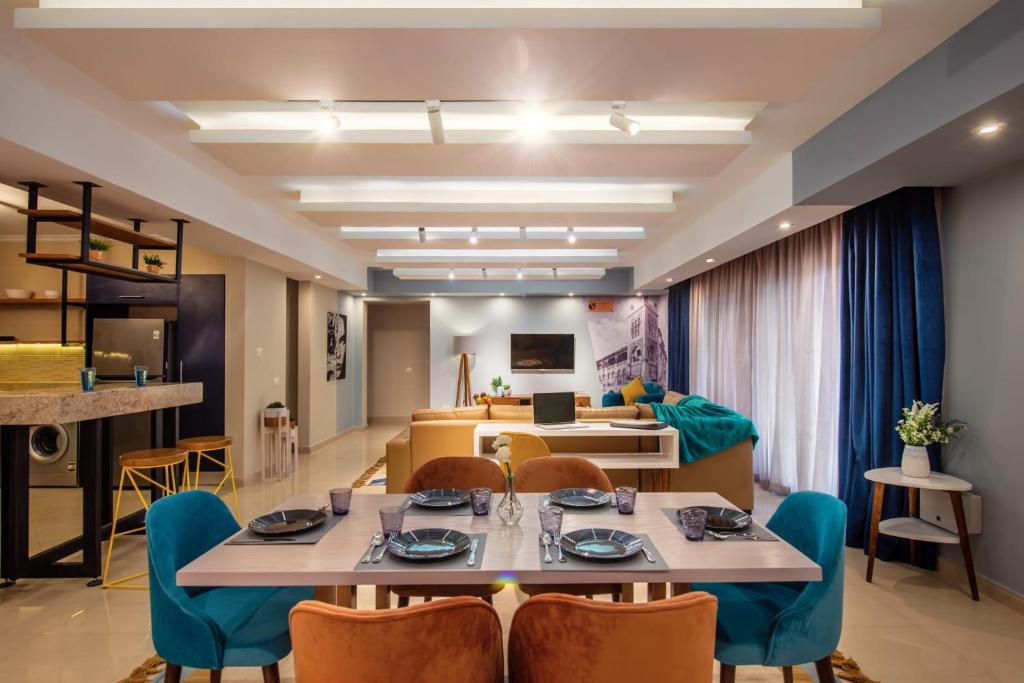開羅的住宿－Waterfront Designer 2BR w Pool Access - 5 min to Airport，用餐室以及带桌椅的起居室。