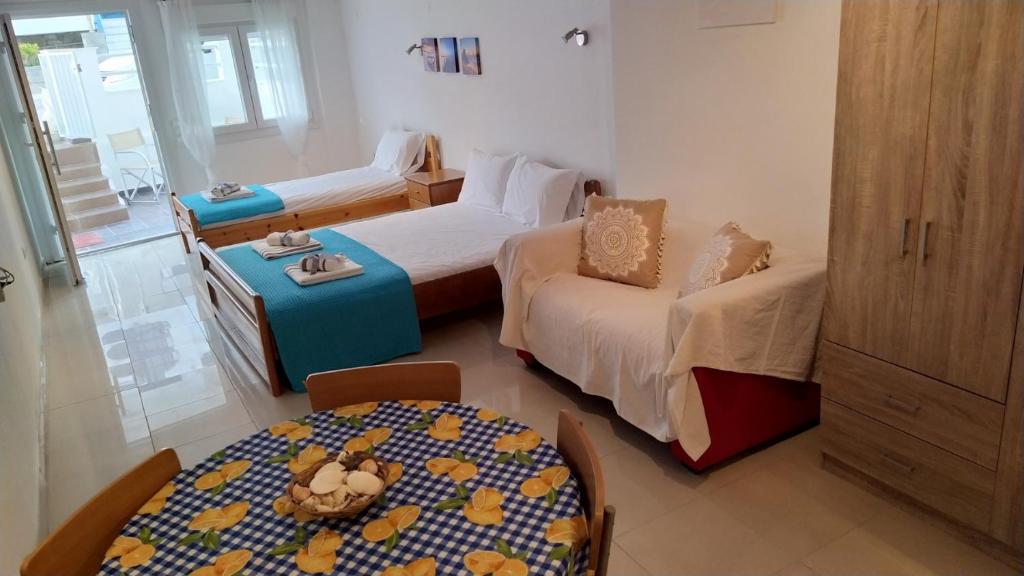 a room with two beds and a table and a table and a room with at Celia`s Studio in Nea Peramos