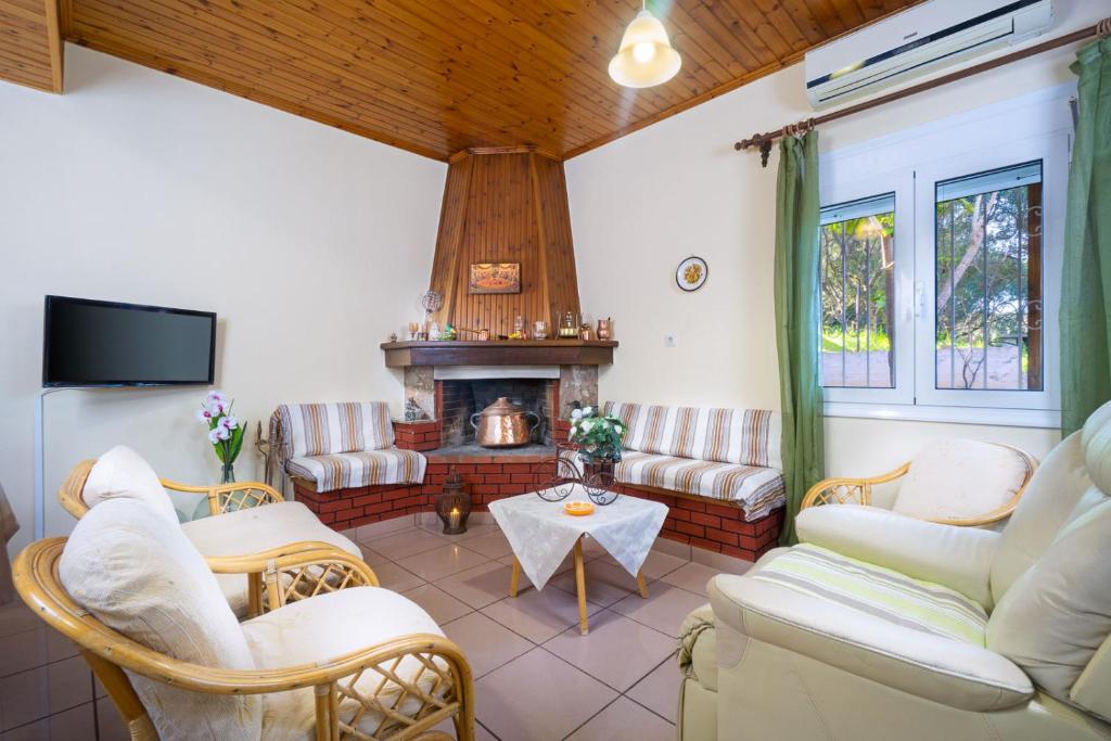 a living room with couches and a fireplace at Taxiarchis Home in Kounoupidhianá