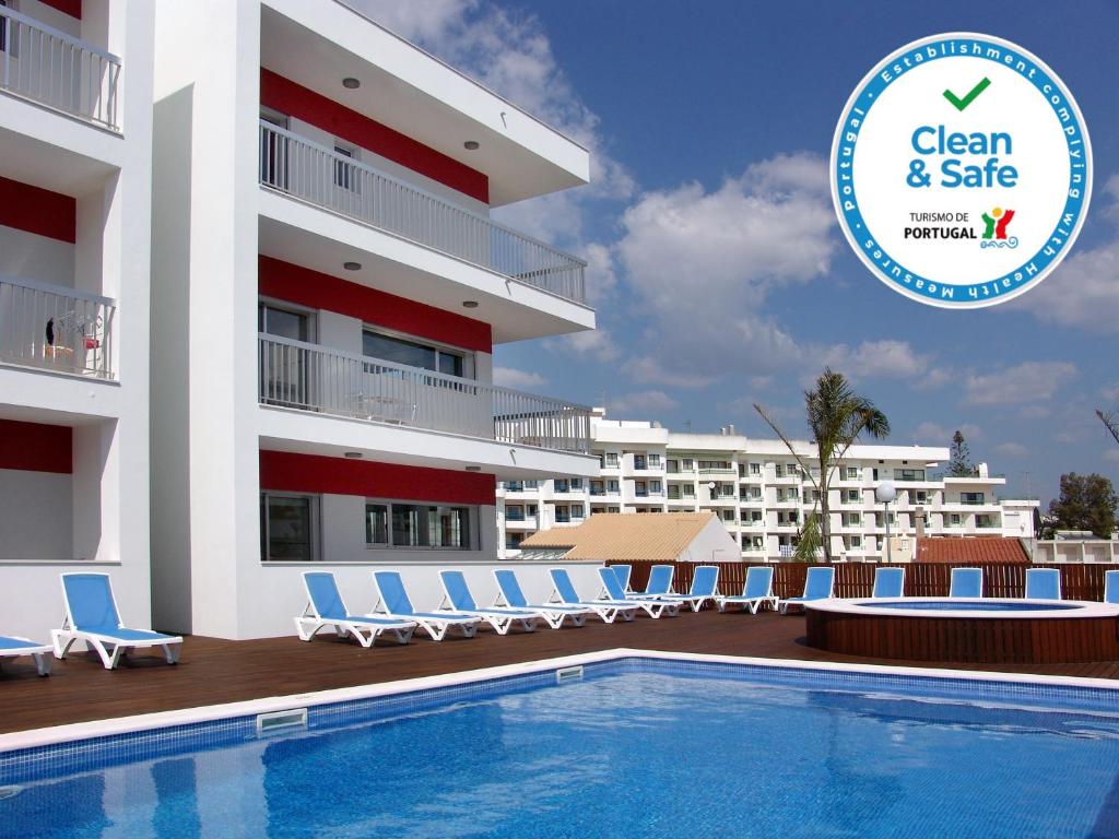 ein Hotel mit einem Pool vor einem Gebäude in der Unterkunft Apartamentos Turisticos Monte da Vinha II in Albufeira