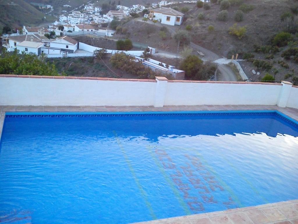 - une piscine bleue avec vue sur la ville dans l'établissement 3 bedrooms house with private pool furnished terrace and wifi at El Borge, à Borge