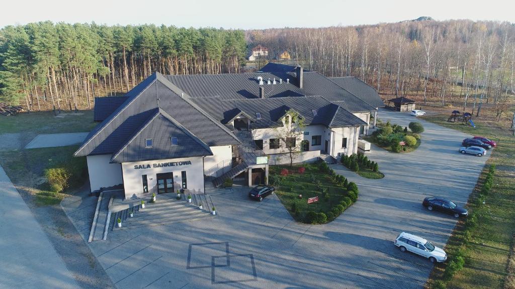eine Luftansicht eines großen Hauses mit einem Parkplatz in der Unterkunft JURAJSKI OLSZTYN in Olsztyn