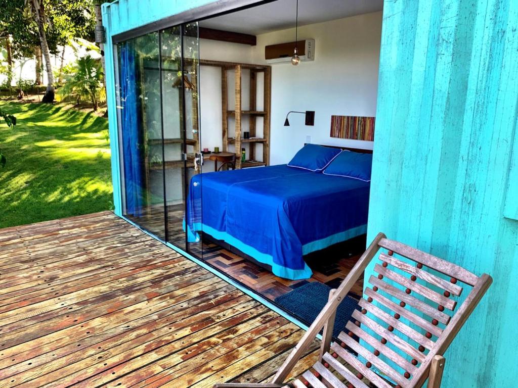 1 dormitorio con cama azul y terraza de madera en Fazenda Vista do Mar, en Serra Grande