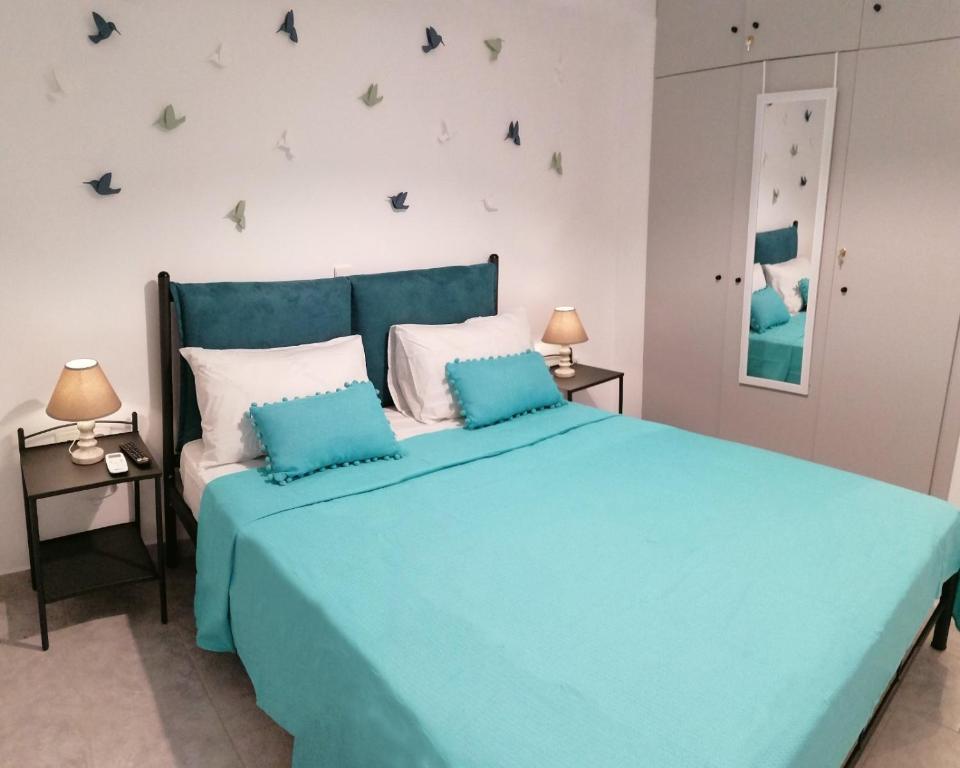 a bedroom with a blue bed with two night stands at FantaSea Apartments in Haraki