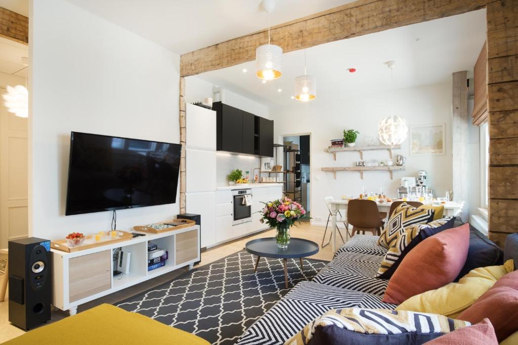 a living room with a couch and a tv at Family Apartment in Tallinn
