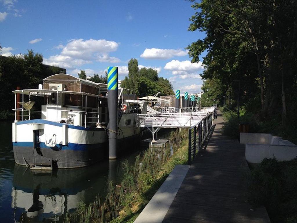 a boat is docked next to a dock at Boat For Guest in Issy-les-Moulineaux