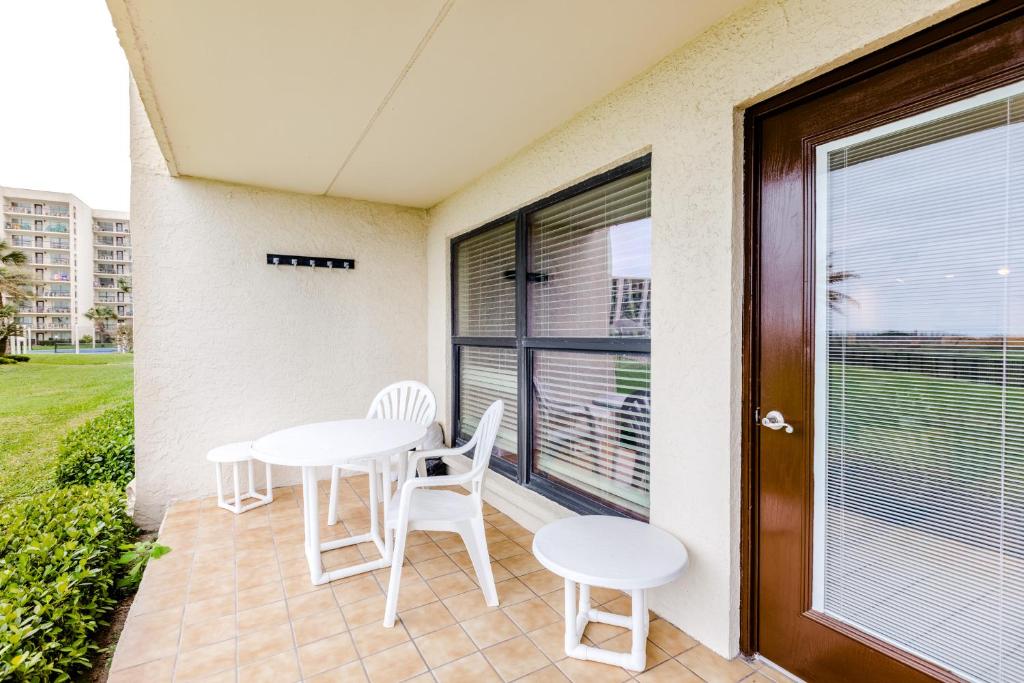 a patio with white chairs and tables and a window at Saida Tower I in South Padre Island