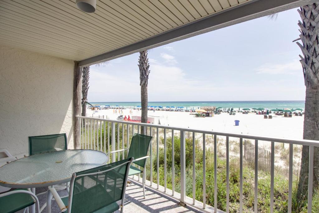 a balcony with a table and chairs and a view of the beach at Nautical Watch A2 in Panama City Beach