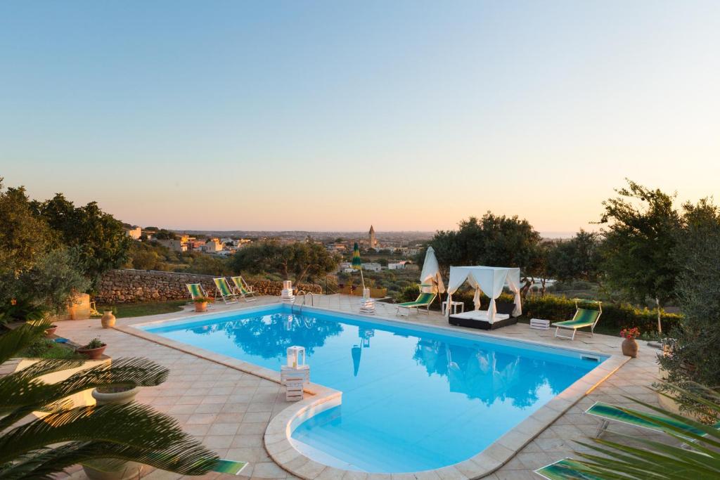 a swimming pool with chairs and a view of the city at 7 bedrooms villa with sea view private pool and furnished terrace at Marsala 5 km away from the beach in Marsala